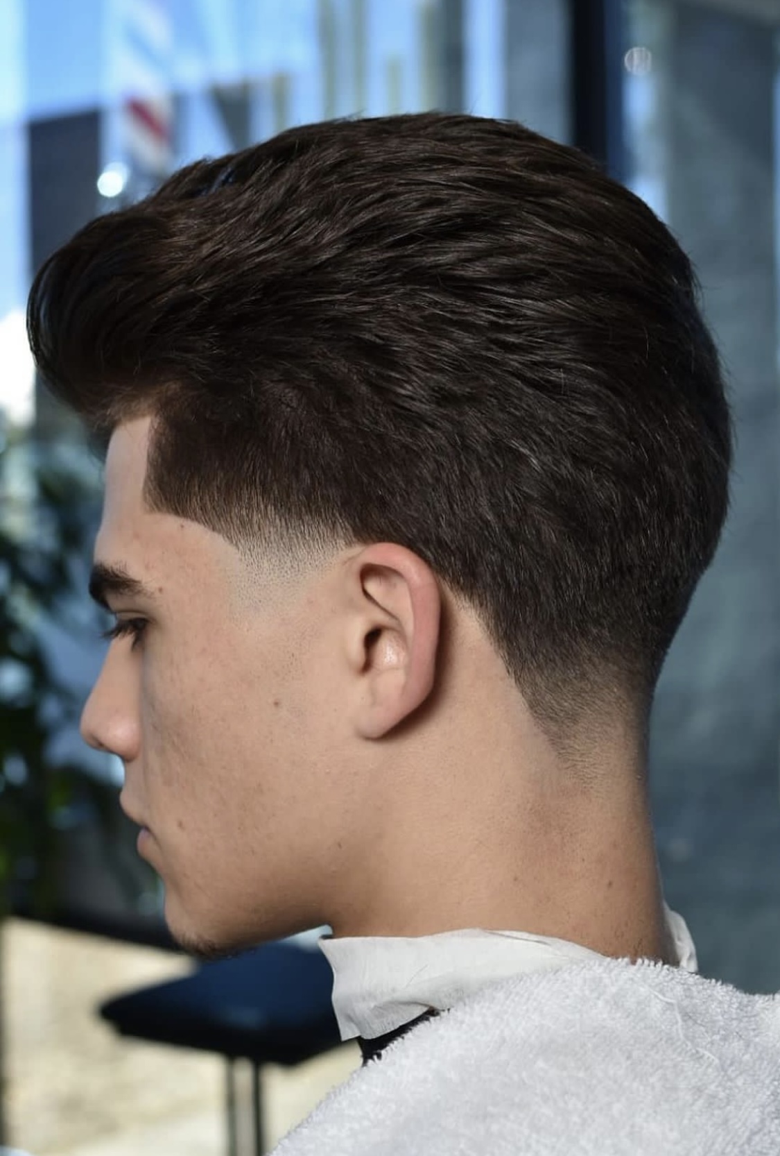 Close-up of a men's textured taper fade haircut, side profile